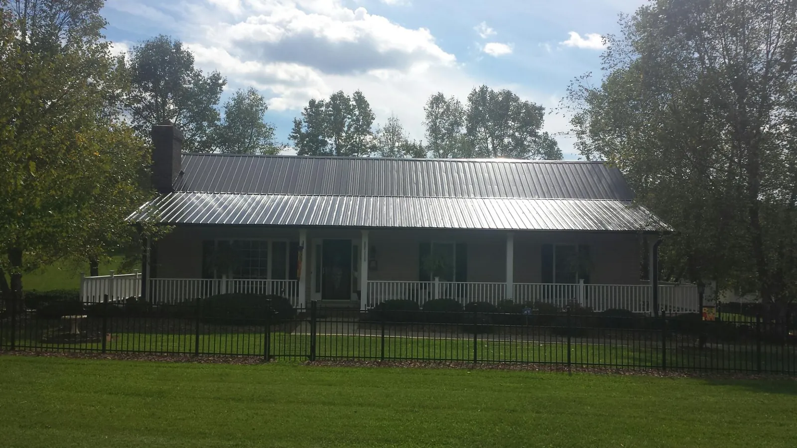 Gray metal roof on a brick ranch with a full width front porch — Gutter Guard Installation work by our crew in Maywood